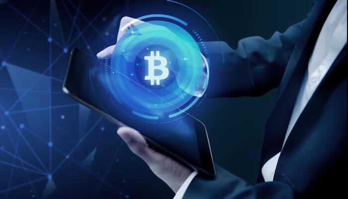 Technological developments - tycoonstory | tycoonstory media A person holding a tab displaying bitcoin that represents bitcoins value against usd