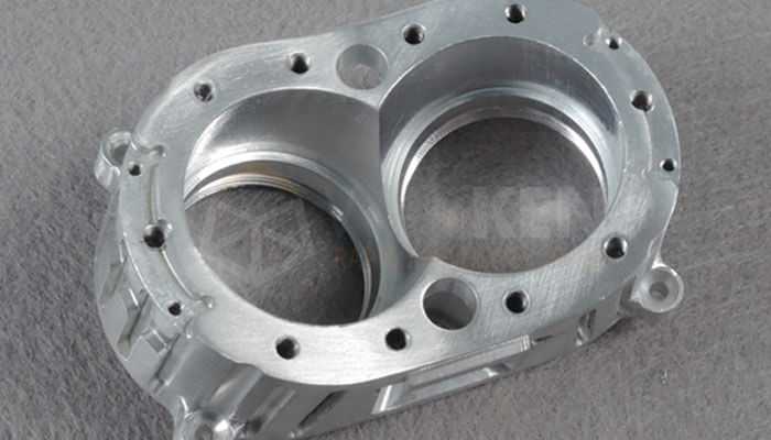 Thermal considerations in machining - tycoonstory | tycoonstory media Precision-machined metal prototype part with two large circular openings and multiple smaller holes.