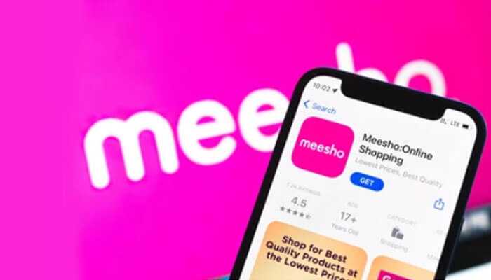 What are the advantages of joining the meesho affiliate program - tycoonstory | tycoonstory media Close-up of a smartphone showing the meesho online shopping app on the app store with a pink background, highlighting opportunities to earn via the meesho affiliate program.