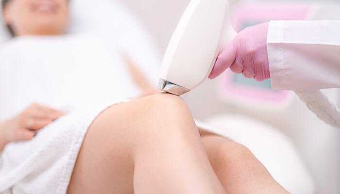 Avoiding hair removal techniques other than shaving - tycoonstory | tycoonstory media A person receiving a laser hair removal treatment on their leg, performed by a professional wearing gloves, in a clinical setting