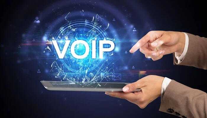 Choosing the right voip solution - tycoonstory | tycoonstory media A person holding a tablet with voip solutions and digital communication technology.