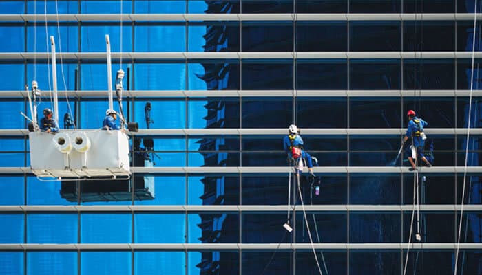 Compliance with health regulations - tycoonstory | tycoonstory media Workers performing commercial cleaning for restaurants on high-rise windows, ensuring cleanliness and safety standards.