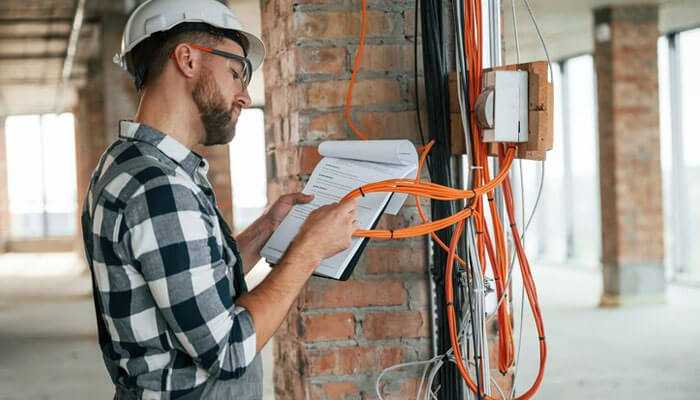 Contractor licence - tycoonstory | tycoonstory media Electrician on building site checking wiring and writing on clipboard, the focus is on minnesota electrical license renewal.