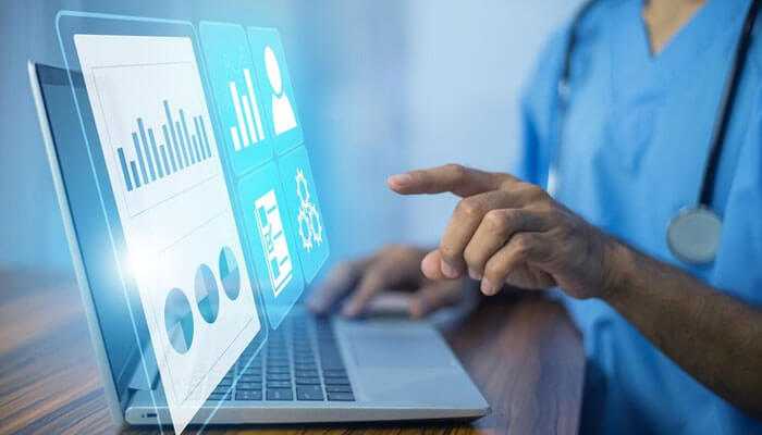 Data-driven decisions - tycoonstory | tycoonstory media Healthcare professional reviewing data on a laptop for healthcare cost management and financial planning.