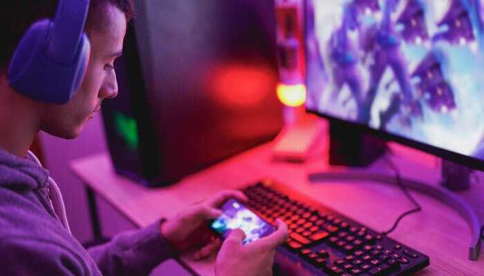 Player using a smartphone and desktop setup to enjoy online games, highlighting mobile and desktop gaming on 111 win.