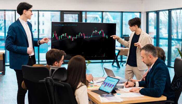 How does lynx add value to your forex tournaments - tycoonstory | tycoonstory media A team of analysts working with the lynx prop trading platform big screen in a modern office.