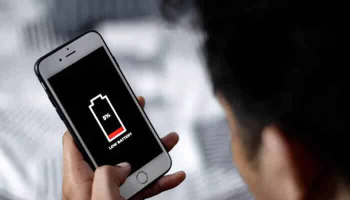 Ignoring battery and resource consumption - tycoonstory | tycoonstory media Person holding a smartphone displaying a low battery warning at 5%, highlighting challenges in mobile application testing.