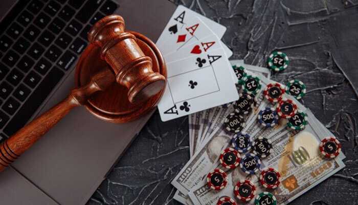 Licensing and regulation - tycoonstory | tycoonstory media A gavel on a laptop beside playing cards, cash, and poker chips-all implying regulation of online gambling and australian online casinos.