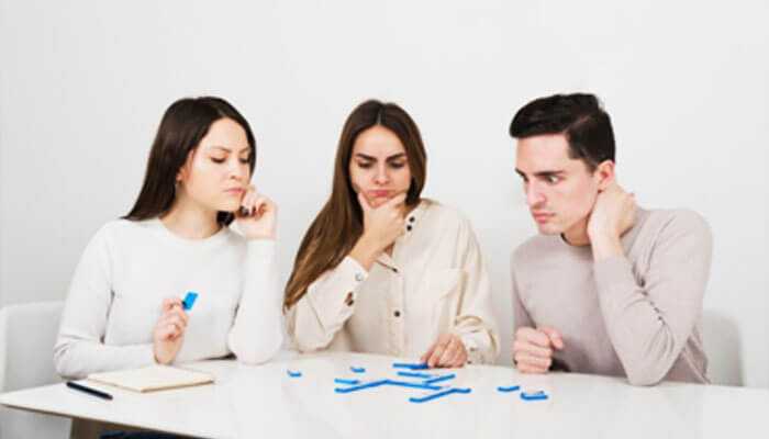 Problem-solving and debugging skills - tycoonstory | tycoonstory media Three men at the table, brooding and intent, consider the jigsaw pieces, a metaphor for problem-solving and collaboration.