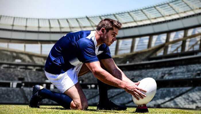 Rugby - tycoonstory | tycoonstory media Rugby player in a stadium setting up the ball for a kick in an international sports tournaments.