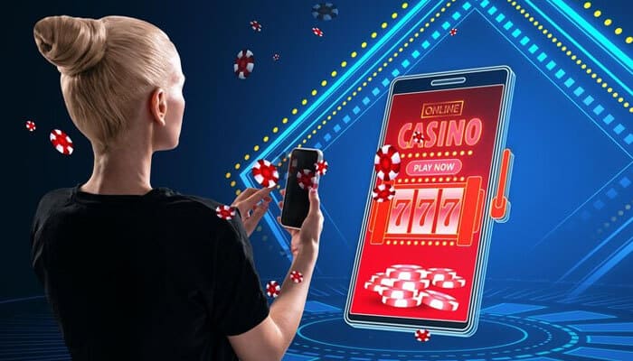 Social influence - tycoonstory | tycoonstory media A person using a smartphone to access an online casino app displaying slot machines, poker chips, and casino promo codes.