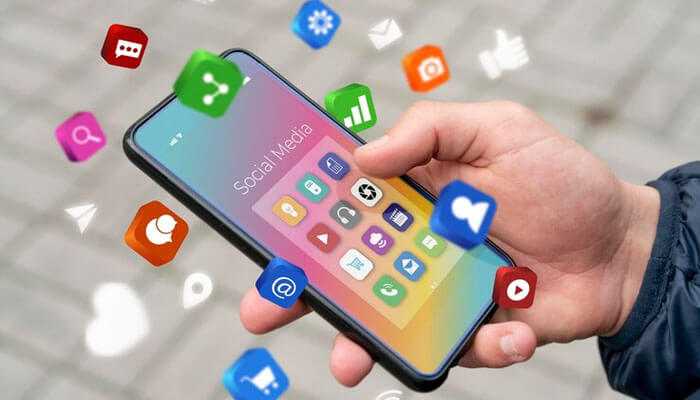 Social media - tycoonstory | tycoonstory media Hand holding a smartphone with various app icons floating around, symbolizing the rise of microtransactions and tech monetization across social media and mobile apps