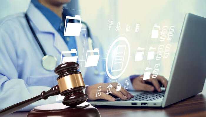 Supporting testimony in a courtroom - tycoonstory | tycoonstory media Healthcare professional working on a laptop with digital files: medical records in personal injury cases.