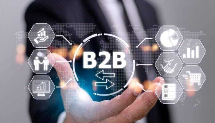 The benefits of b2b e-commerce development for business growth - tycoonstory | tycoonstory media A business professional holding a virtual b2b icon surrounded by digital graphics, symbolizing concepts about b2b ecommerce development.