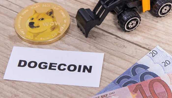 The environmental debate - tycoonstory | tycoonstory media A physical dogecoin token next to a toy excavator, a'Dogecoin' label, and Euro banknotes on a wooden surface.