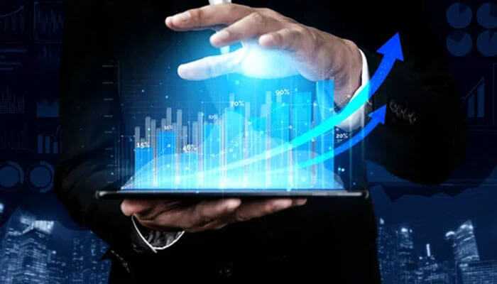 The role of technology and innovation - tycoonstory | tycoonstory media A person holding a tablet with holographic graphs and upward trends-k upon growth investing, financial growth.