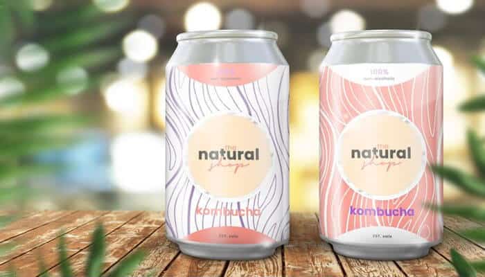 Top custom drinkware for your event - tycoonstory | tycoonstory media Two kombucha cans with custom natural-themed labels on a wood surface displaying custom drinkware favors.