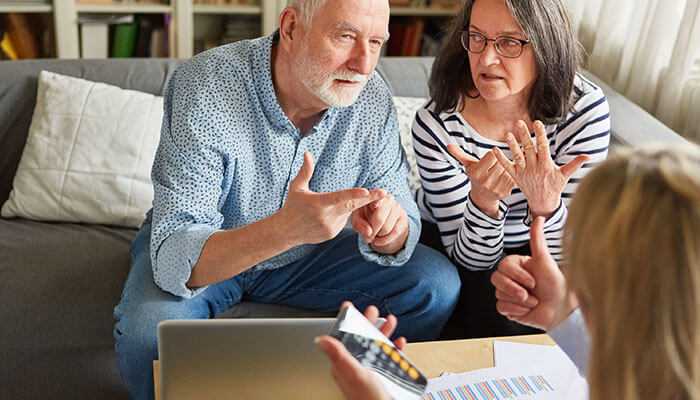 What lifestyle would you like and what are your priorities - tycoonstory | tycoonstory media Senior couple saving for retirement, discussing financial strategies with a financial advisor, reviewing documents and calculations to secure a comfortable future