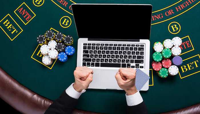 Why track your winnings - tycoonstory | tycoonstory media Overhead view of an online poker player celebrating a win at a table with poker chips, cards, and a laptop, symbolizing tracking poker winnings with cryptocurrency