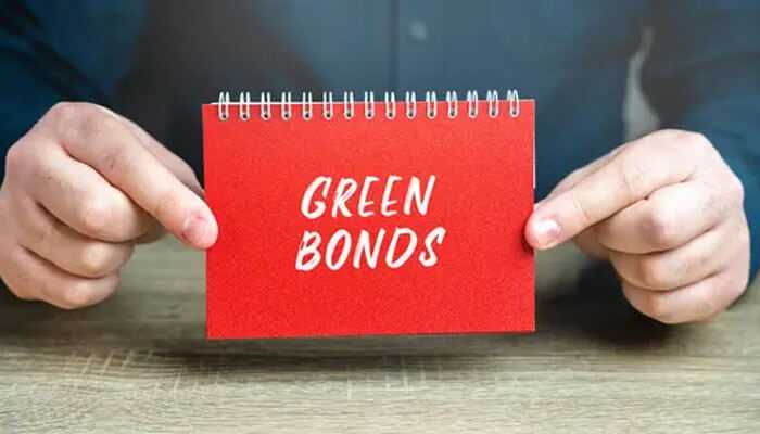 Benefits for investors and issuers - tycoonstory | tycoonstory media A person holding a red notepad with green bonds written, emphasizing concepts of sustainable investing.