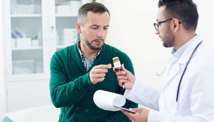 Consult a health care provider - tycoonstory | tycoonstory media A doctor explaining a prescription medication, including tadalafil, during a consultation in a medical office.