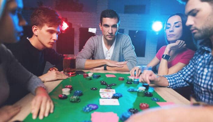 Control your gambling habits stay safe - tycoonstory | tycoonstory media Group playing poker at green table with chips and cards, while showing awareness in online gambling safety.