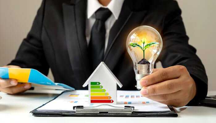 Energy efficiency and savings - tycoonstory | tycoonstory media Hvac system for your business showing a professional holding a lightbulb with a plant, energy chart, and house model