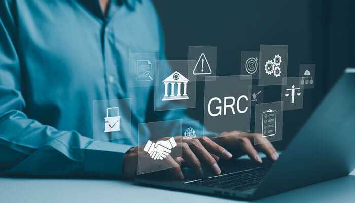 Enhancing decision-making with grc data - tycoonstory | tycoonstory media Business professional working on a laptop with floating icons representing governance, risk, and compliance (grc) concepts in a technology-driven environment