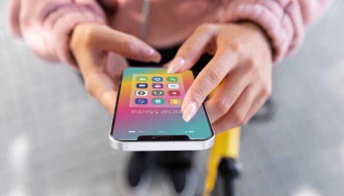 How to protect yourself from fake apps - tycoonstory | tycoonstory media Close-up of hands holding a smartphone with colorful social media app icons, emphasizing the need to avoid phishing and fake apps