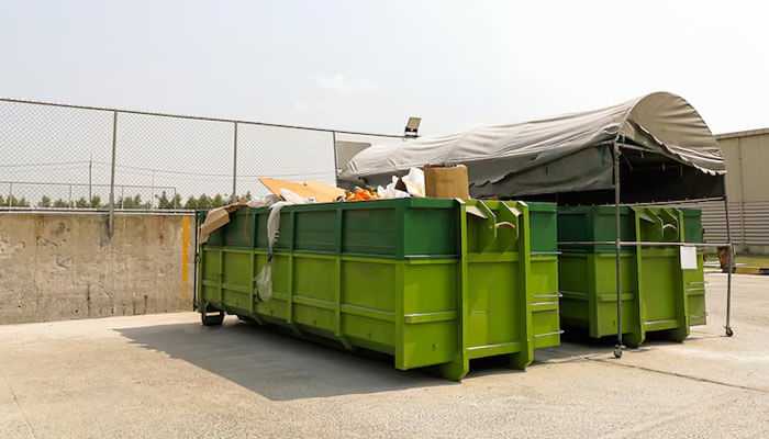 Renting a dumpster in las vegas is a simple process - tycoonstory | tycoonstory media Large green 30 yard dumpster filled with construction and renovation debris, placed outdoors near a fenced area