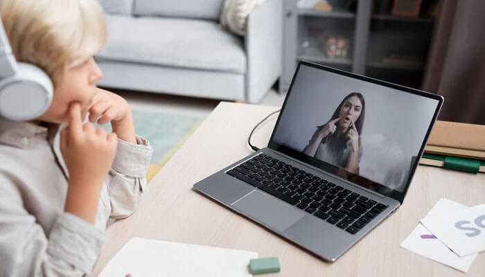 Telepractice working with clients wherever they are - tycoonstory | tycoonstory media Child participating in a virtual speech therapy session with therapist via laptop.