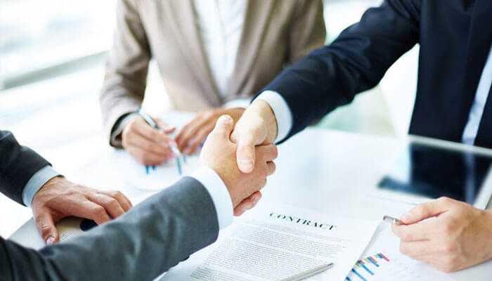 The power of collaboration - tycoonstory | tycoonstory media Business professionals shaking hands over a contract, symbolizing successful partnerships highlighted by mehroz azam.