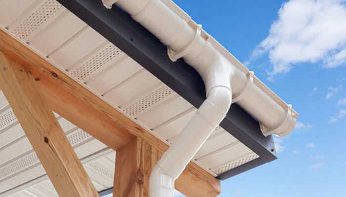 Where to order pvc pipes - tycoonstory | tycoonstory media White pvc rain gutter system on the wooden structure, with the blue sky showing through.