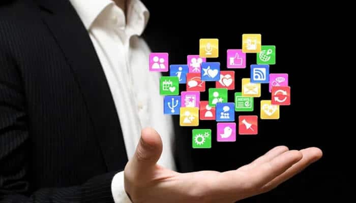 Access to a growing app marketplace - tycoonstory | tycoonstory media Hand holding floating icons of apps representing android app development for social media, utilities, and communication.