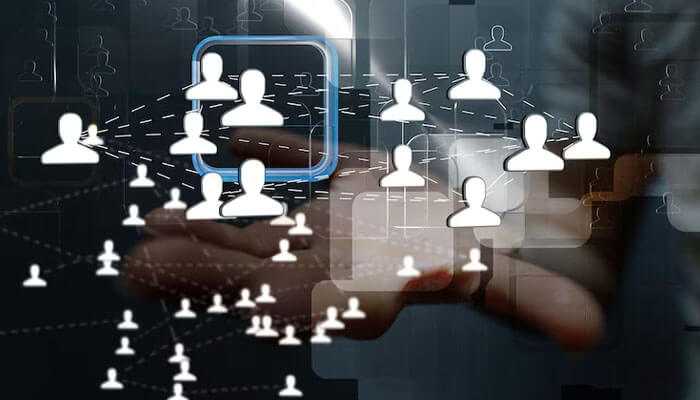 Engage with your audience - tycoonstory | tycoonstory media Interconnected user icons, with a hand interacting, which symbolizes building a brand identity through network connections.