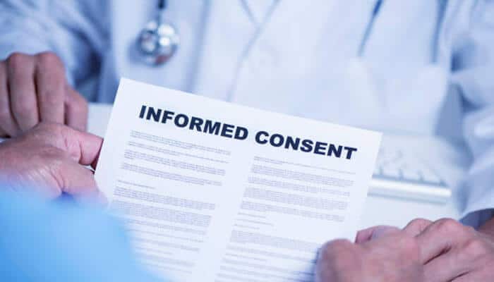 Practicing informed consent - tycoonstory | tycoonstory media Doctor presenting informed consent to a patient, for the latter to make an informed decision for safer medical care.
