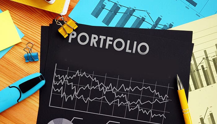 Rebalance your portfolio- tycoonstory | tycoonstory media The image shows a portfolio document with financial graphs, office supplies, and charts, highlighting risk management and investment analysis.