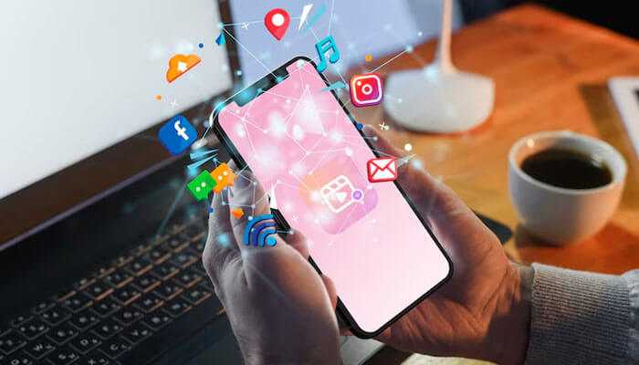 Socialmedia creation - tycoonstory | tycoonstory media Ryan garcia net worth: a smartphone with floating social icons, signifying connection, together with a laptop and coffee at a productive workplace.