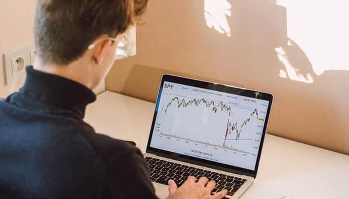 Steps to start online trading in bangladesh - tycoonstory | tycoonstory media A person analyzing a stock market chart on a laptop screen, representing the growing trend of online trading in bangladesh and its financial opportunities
