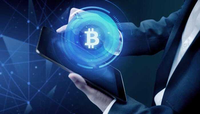 Technology powering the tokenization revolution 1 | tycoonstory media Businessman operating on a glowing bitcoin symbol tab representing digital assets, blockchain, and cryptocurrency-based transactions in his tokenization real estate investments.