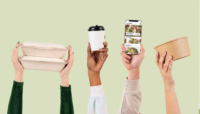 Innovations in compostable packaging - tycoonstory | tycoonstory media Hands holding compostable bakery packaging, a reusable coffee cup, and a phone promoting food with an app.