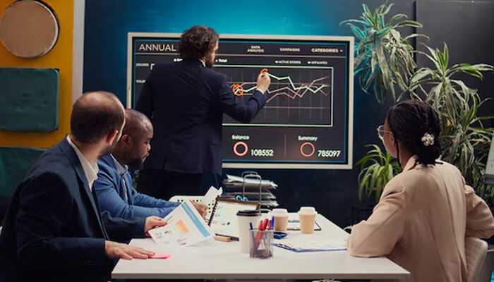 Advanced investment strategies and platforms - tycoonstory | tycoonstory media Team discussion around a digital performance dashboard during a training session, showcasing collaborative insights from investment learning platforms.