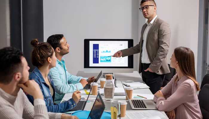 Best ways to build expertise in management - tycoonstory | tycoonstory media Grow your management expertise – business team in a meeting, discussing data and analytics with a presenter leading the discussion.
