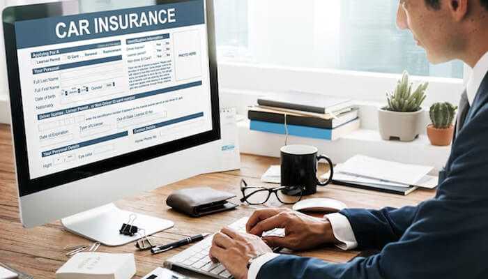 Factors leading to loss of ncb in car insurance - tycoonstory | tycoonstory media A businessman reviewing a car insurance policy on a computer screen, highlighting the importance of ncb in lowering car insurance premiums.