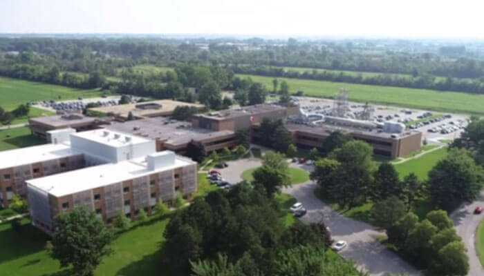 Industrial parks a model for economic growth - tycoonstory | tycoonstory media Industrial parks aerial that includes several buildings, parking lots, and green spaces, surrounded by open fields.