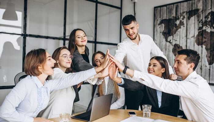 Leadership and team management - tycoonstory | tycoonstory media Hiring a coo qualities – a collaborative business team celebrating success in a modern office environment.