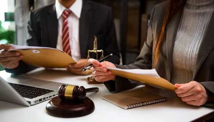 Legal representation - tycoonstory | tycoonstory media The image shows legal professionals reviewing documents, symbolizing legal counsel, which ensures compliance, protects rights, and provides strategic legal solutions.