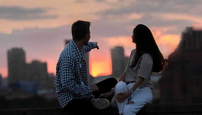 Love and relationships - tycoonstory | tycoonstory media A couple enjoying a sunset, with the man pointing towards the horizon, symbolizing connection and love, reflecting the energy and balance associated with the 666 angel number meaning.