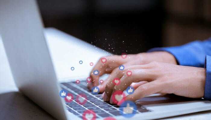 Online presence - tycoonstory | tycoonstory media Haris&co: person typing on a laptop with floating social media like and heart icons.