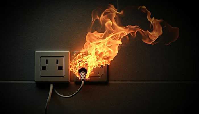 Power outlets smell - tycoonstory | tycoonstory media A wall electrical outlet with a plugged-in cord catching fire, highlighting the dangers of faulty wiring, electrical overload, and the need for home rewiring.